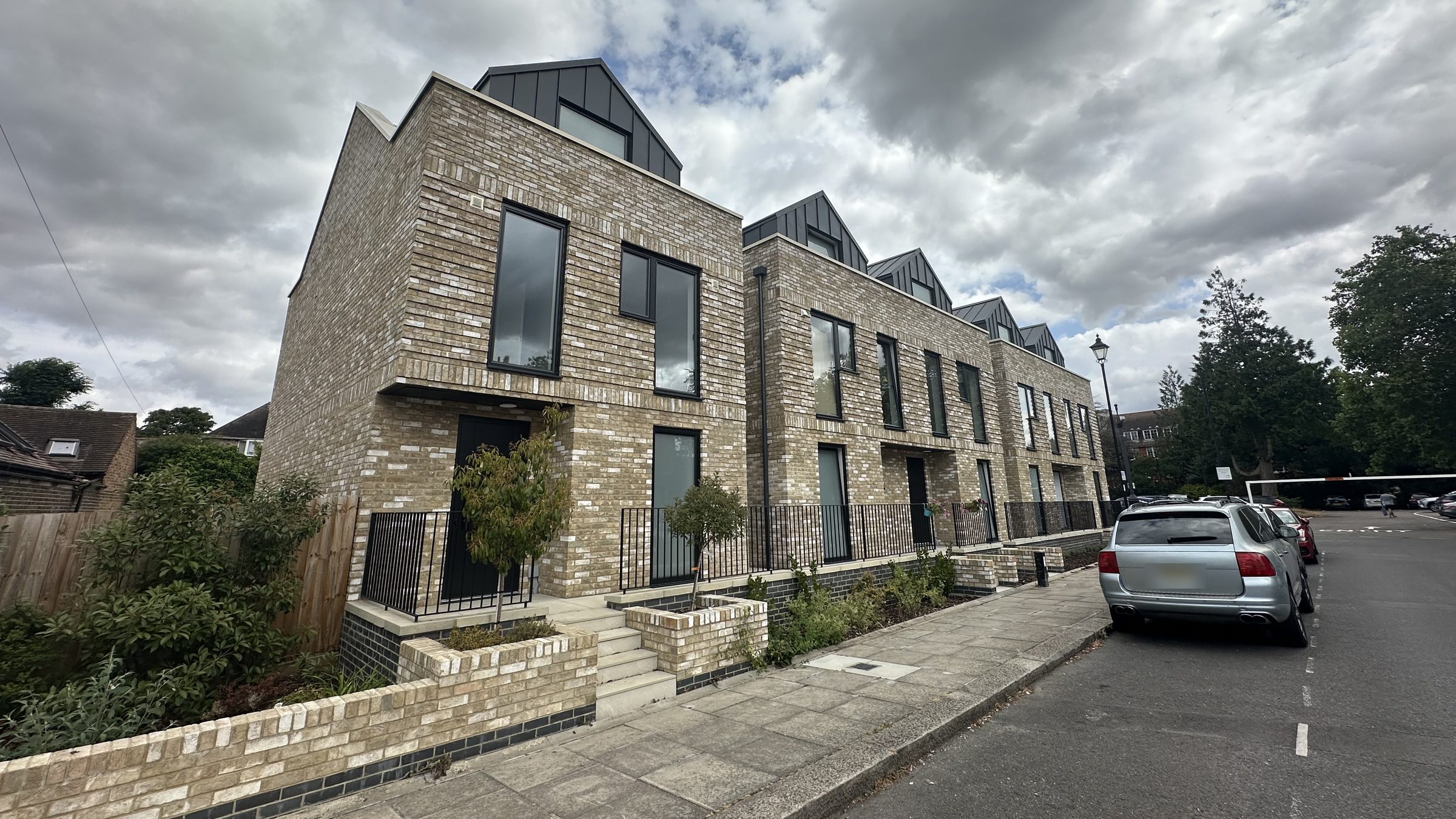 Terrace of new brick townhouses with standing-seam roofs